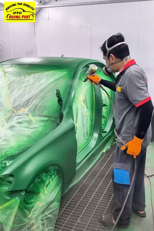 Đổi màu sơn Mercedes C200 từ màu đen sang màu xanh Kỹ thuật viên đang phủ lớp sơn tạo hiệu ứng mờ cho xe